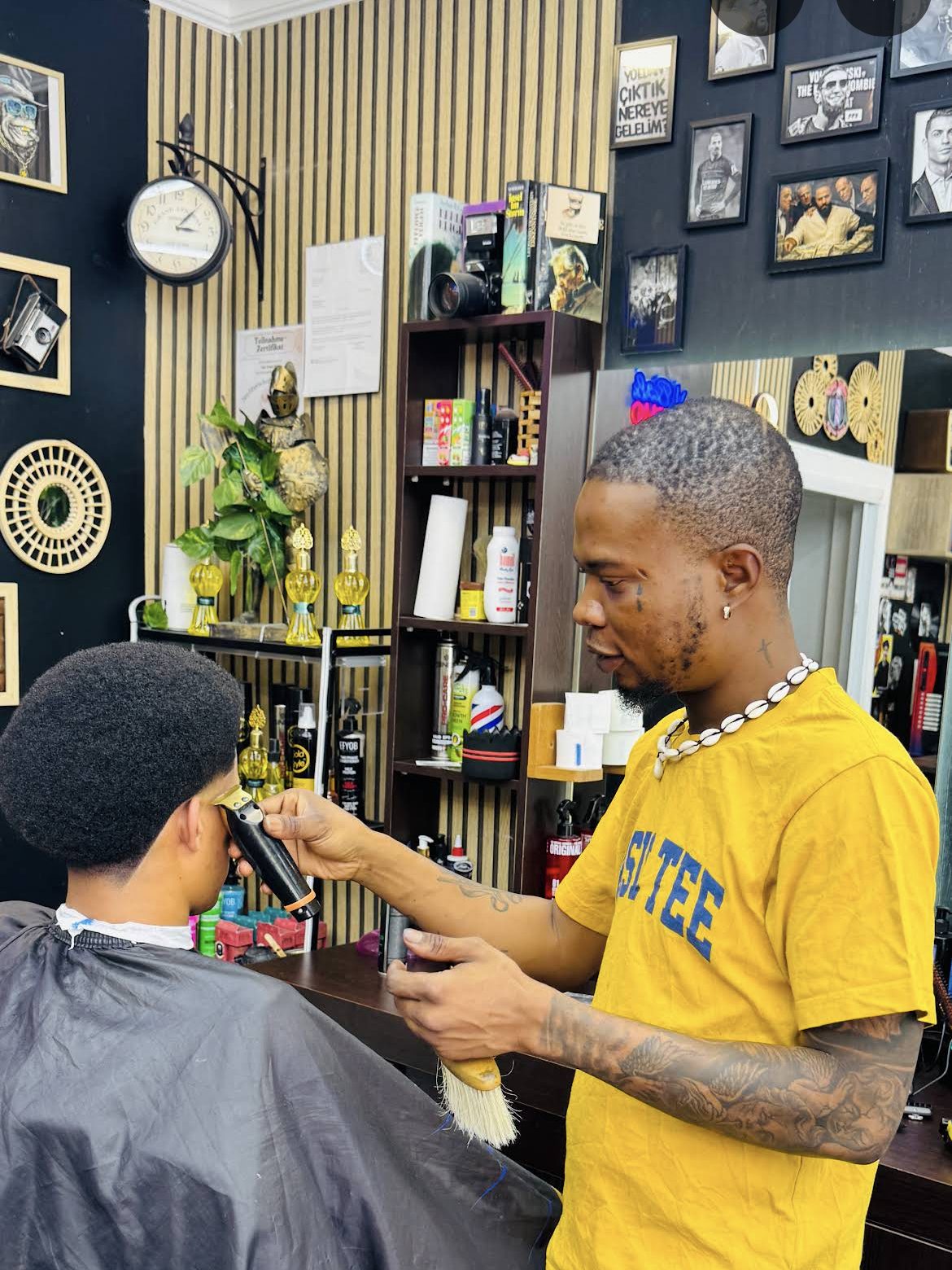 The barber at Gentle Touch trimming a client's line-up with a trimmer