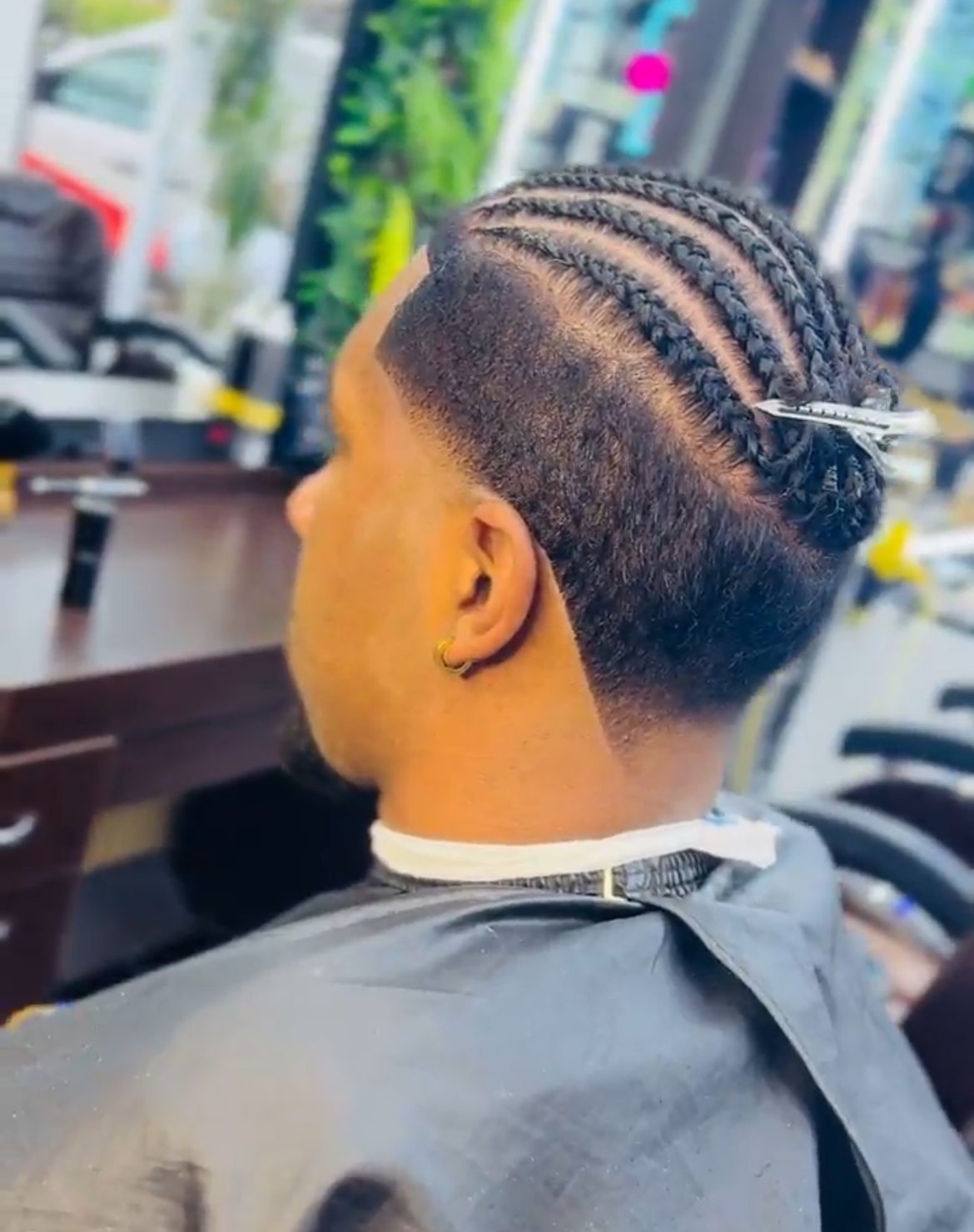 Straight-back cornrows with a low fade, rear three-quarter view